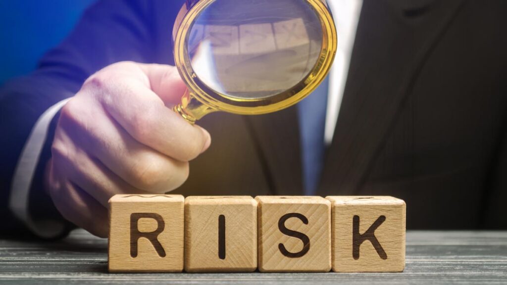 Hand Holding Magnifying Glass Looking at Risks