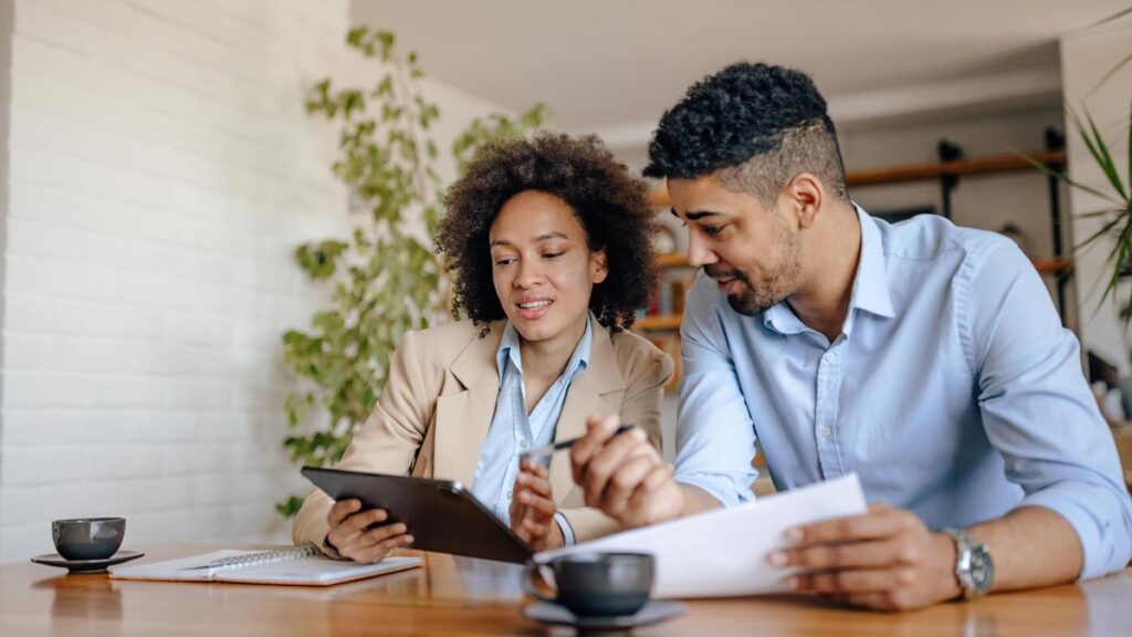 Couple Reviewing Tablet and Papers