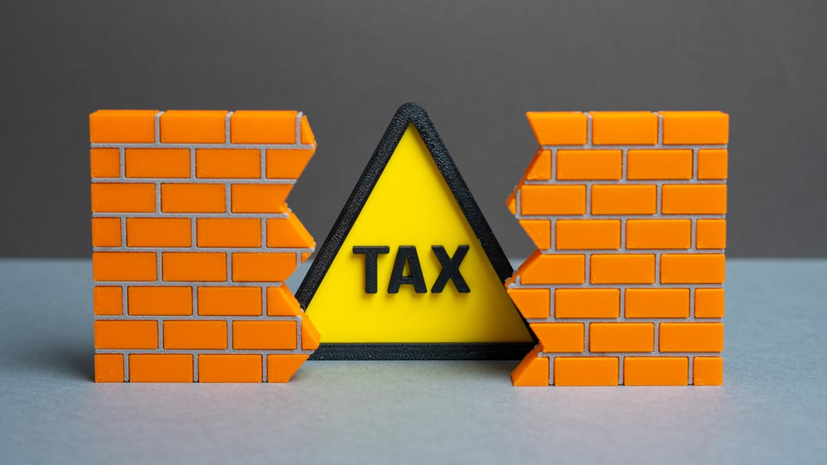 TAX Caution Sign Behind Brick Wall